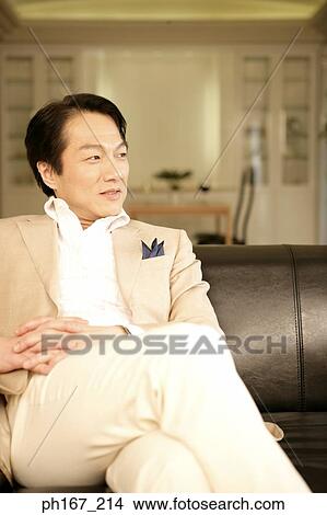 Picture - Man sitting at couch. Fotosearch