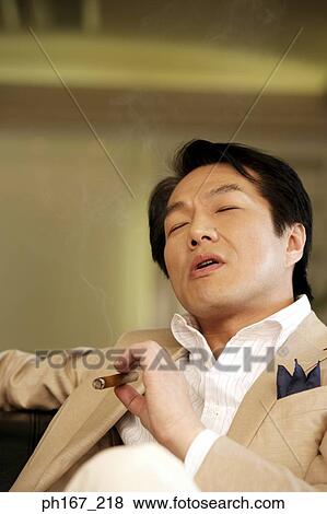 Stock Photo - Man smoking a cigar . Fotosearch