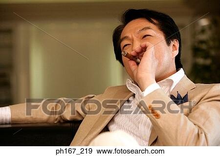 Stock Photo - Man smoking a cigar . Fotosearch