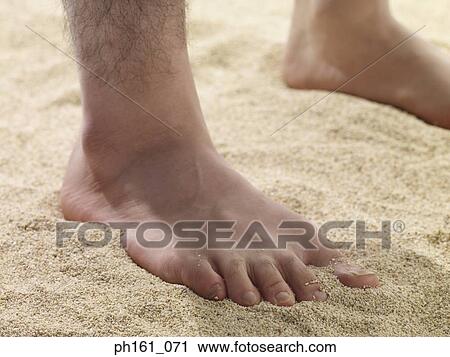 Stock Image - Man standing on sand. Fotosearch