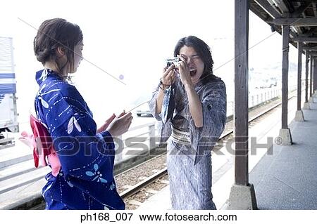 Stock Photo - Man taking a picture of woman in kimono. Fotosearch
