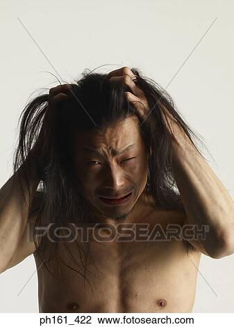 Stock Image - Man with hands in his long hair. Fotosearch
