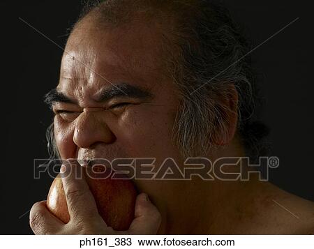 Mature man biting into an apple View Large Photo Image Stock Image - Mature man biting into an apple. Fotosearch