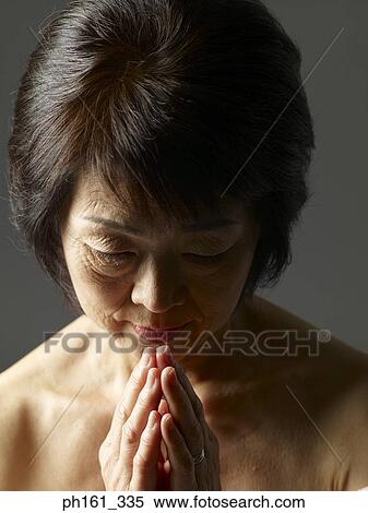 Mature woman with head down, hands together View Large Photo Image Stock Photography - Mature woman with head down, hands together. Fotosearch