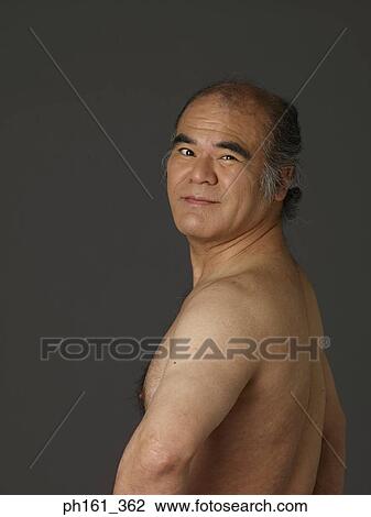 Stock Image - Portrait of a shirtless man turning back to face the camera. Fotosearch