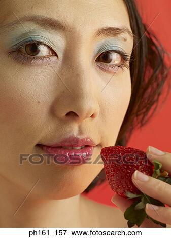 Portrait of a woman holding a strawberry View Large Photo Image Stock Photo - Portrait of a woman holding a strawberry. Fotosearch