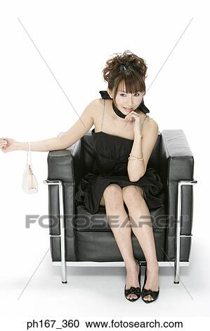Stock Image - Portrait of a woman sitting on a sofa. Fotosearch