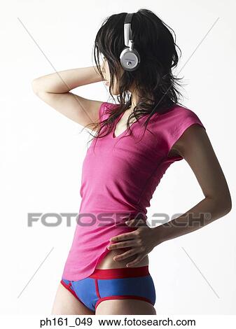 Portrait of a young woman in pink T shirt, briefs and head phones, side view View Large Photo Image Stock Photo - Portrait of a young woman in pink T shirt, briefs and head phones, side view. Fotosearch