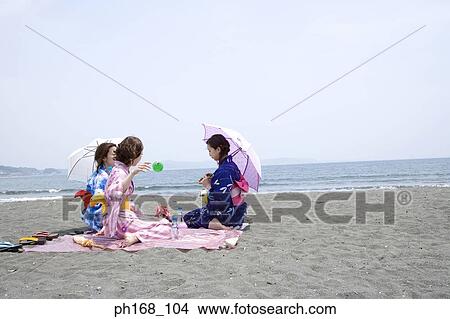 Picture - Three women sitting by the beach. Fotosearch