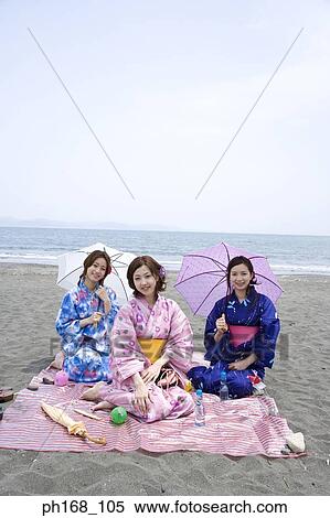 Three women sitting by the beach View Large Photo Image Stock Photography - Three women sitting by the beach. Fotosearch