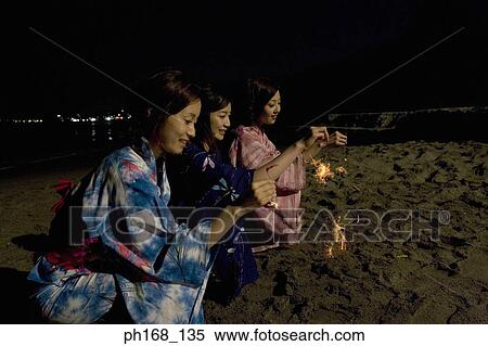 Three women with sparklers by the beach at night View Large Photo Image Stock Photography - Three women with sparklers by the beach at night. Fotosearch