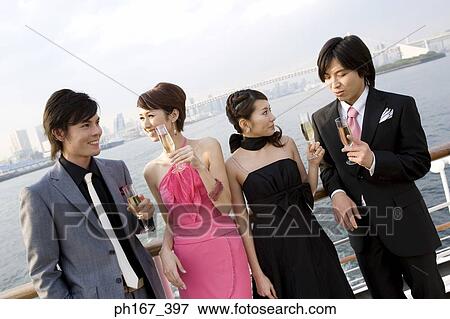 Two couple having champagne onboard a cruise ship View Large Photo Image Stock Photo - Two couple having champagne onboard a cruise ship. Fotosearch
