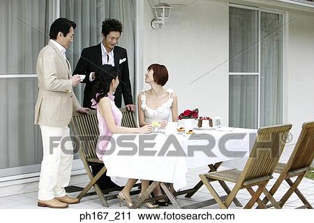 Two couples by the dining table, outdoor View Large Photo Image Stock Image - Two couples by the dining table, outdoor. Fotosearch