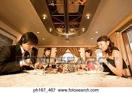 Two couples enjoying a meal View Large Photo Image Stock Photo - Two couples enjoying a meal. Fotosearch