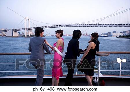 Two couples enjoying the view on cruise ship, rear view View Large Photo Image Stock Photo - Two couples enjoying the view on cruise ship, rear view. Fotosearch