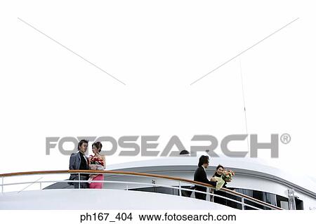Picture - Two couples enjoying the view onboard a cruise ship. Fotosearch