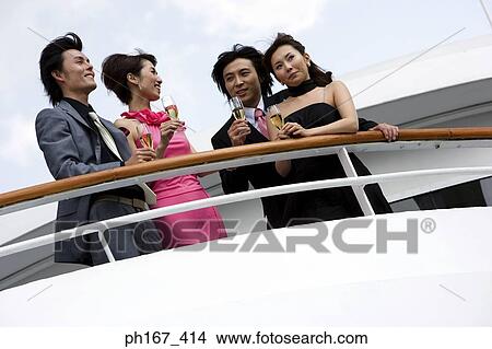 Picture - Two couples enjoying the view onboard a cruise ship. Fotosearch