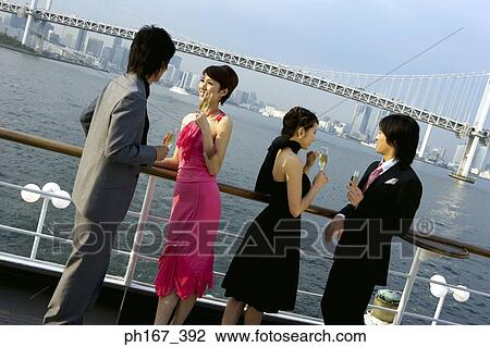 Stock Image - Two couples enjoying the view onboard a cruise ship. Fotosearch