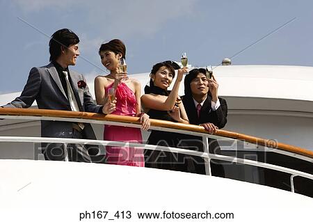 Stock Image - Two couples enjoying the view onboard a cruise ship. Fotosearch