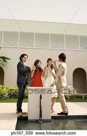 Two couples having cocktails in the courtyard View Large Photo Image Stock Photo - Two couples having cocktails in the courtyard. Fotosearch