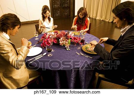 Two couples having dinner View Large Photo Image Stock Photo - Two couples having dinner. Fotosearch