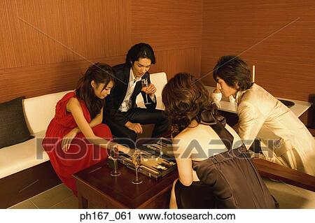 Two couples playing backgammon View Large Photo Image Stock Image - Two couples playing backgammon. Fotosearch