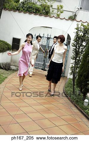 Stock Photography - Two couples walking through the gate. Fotosearch