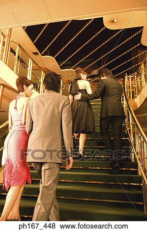 Stock Photo - Two couples walking up the stairs, rear view. Fotosearch