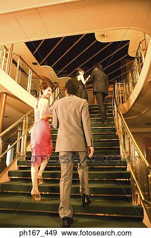 Stock Photo - Two couples walking up the stairs, rear view. Fotosearch
