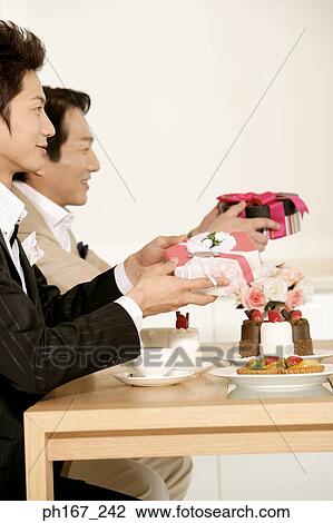 Two men holding gifts View Large Photo Image Stock Image - Two men holding gifts. Fotosearch