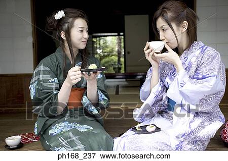 Two women in kimono having food by the corridor View Large Photo Image Stock Photo - Two women in kimono having food by the corridor. Fotosearch