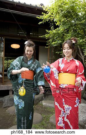 Two women in kimono having fun in the garden View Large Photo Image Picture - Two women in kimono having fun in the garden. Fotosearch