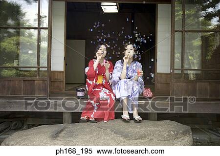 Stock Photography - Two women in kimono playing with bubbles. Fotosearch