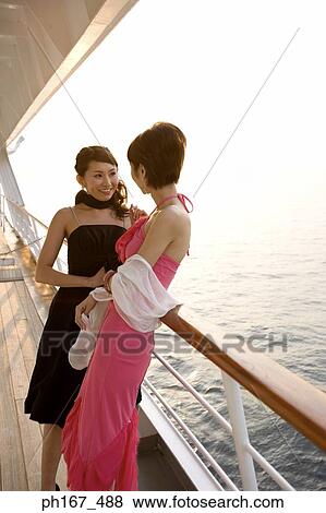 Two women leaning on railing on cruise ship View Large Photo Image Stock Photo - Two women leaning on railing on cruise ship. Fotosearch