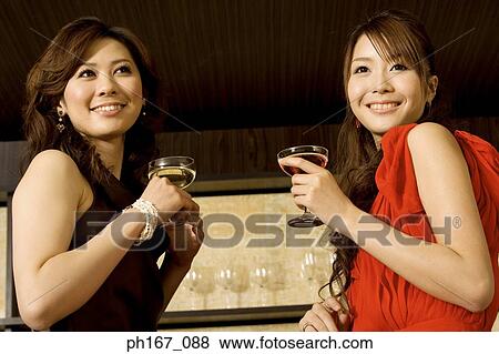 Stock Photo - Two women relaxing by the bar, close-up. Fotosearch
