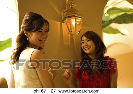 Two women standing by corridor View Large Photo Image Stock Photo - Two women standing by corridor. Fotosearch