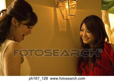 Stock Photo - Two women standing by corridor. Fotosearch