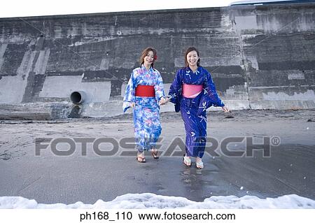 Two women taking a walk by the beach View Large Photo Image Stock Image - Two women taking a walk by the beach. Fotosearch