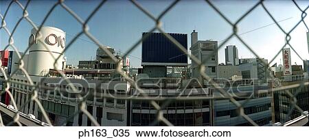 Stock Photography - View of buildings seen through a fence. Fotosearch