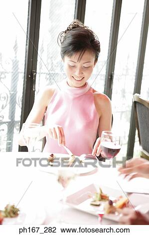 Woman eating in a restaurant View Large Photo Image Stock Image - Woman eating in a restaurant . Fotosearch