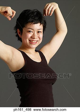 Stock Photo - Woman flexing her muscles, smiling. Fotosearch