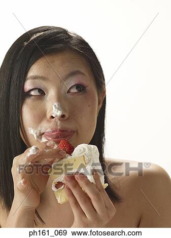 Woman holding a cake with cream on her face View Large Photo Image Stock Photo - Woman holding a cake with cream on her face. Fotosearch