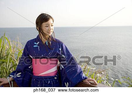 Woman in a kimono by beach View Large Photo Image Stock Photo - Woman in a kimono by beach. Fotosearch