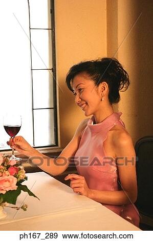 Woman in a restaurant with a glass of wine View Large Photo Image Stock Photo - Woman in a restaurant with a glass of wine. Fotosearch