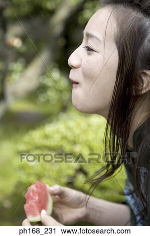 Woman in kimono biting into water melon, side view View Large Photo Image Stock Image - Woman in kimono biting into water melon, side view. Fotosearch