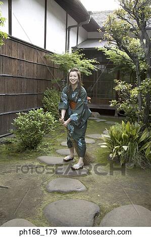Stock Photo - Woman in kimono holding a broom. Fotosearch