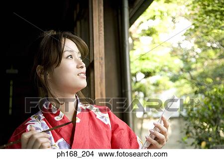 Woman in kimono holding a paintbrush and book View Large Photo Image Picture - Woman in kimono holding a paintbrush and book. Fotosearch