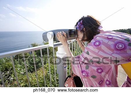 Woman in kimono looking through a binoculars View Large Photo Image Stock Image - Woman in kimono looking through a binoculars. Fotosearch