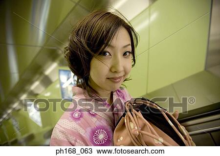 Stock Image - Woman in kimono on an escalator. Fotosearch