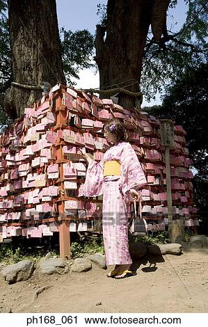 Woman in kimono standing in front of a panel of fortune slips View Large Photo Image Stock Image - Woman in kimono standing in front of a panel of fortune slips. Fotosearch